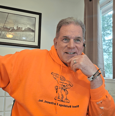 Smiling person wearing orange hoodie indoors